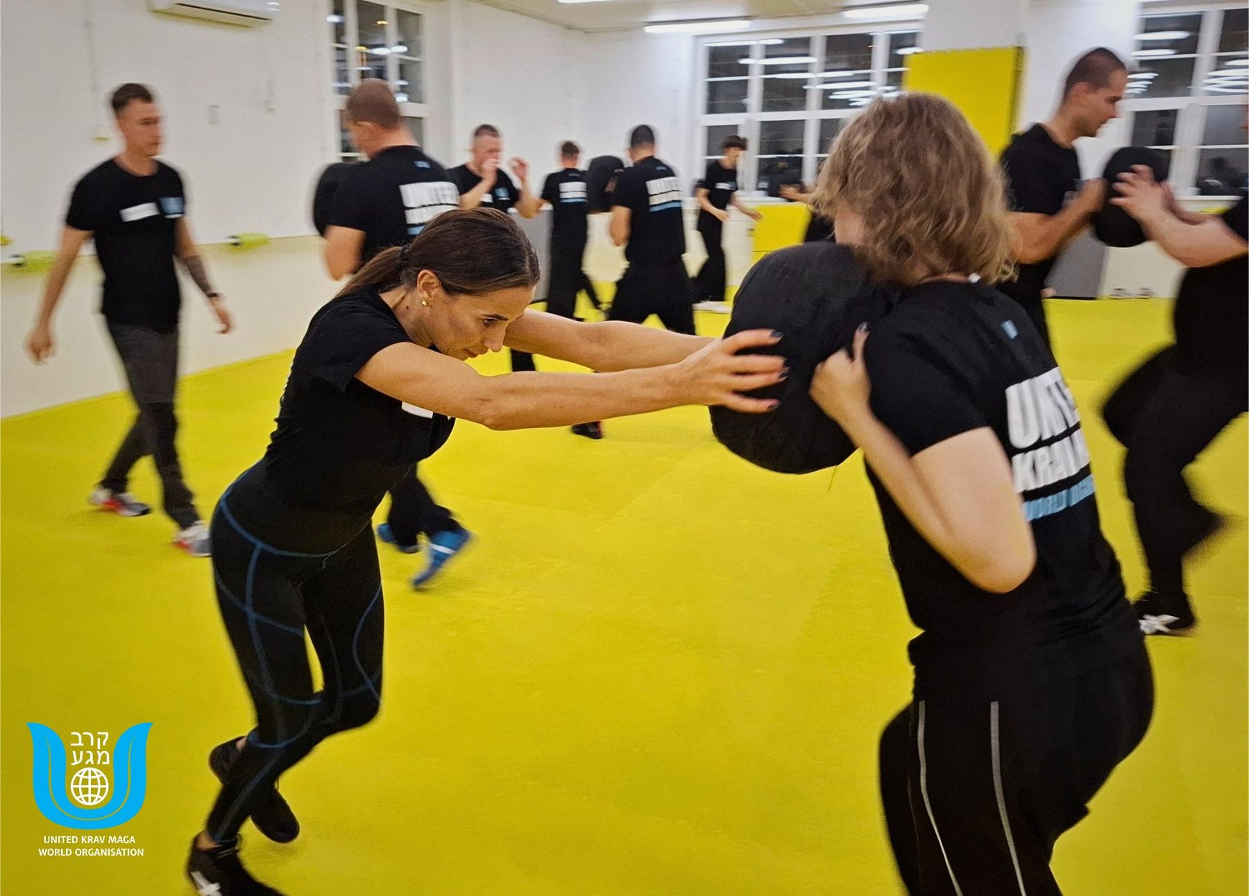 Uczestniczki trenują z workiem na treningu samoobrony United Krav Maga Wrocław