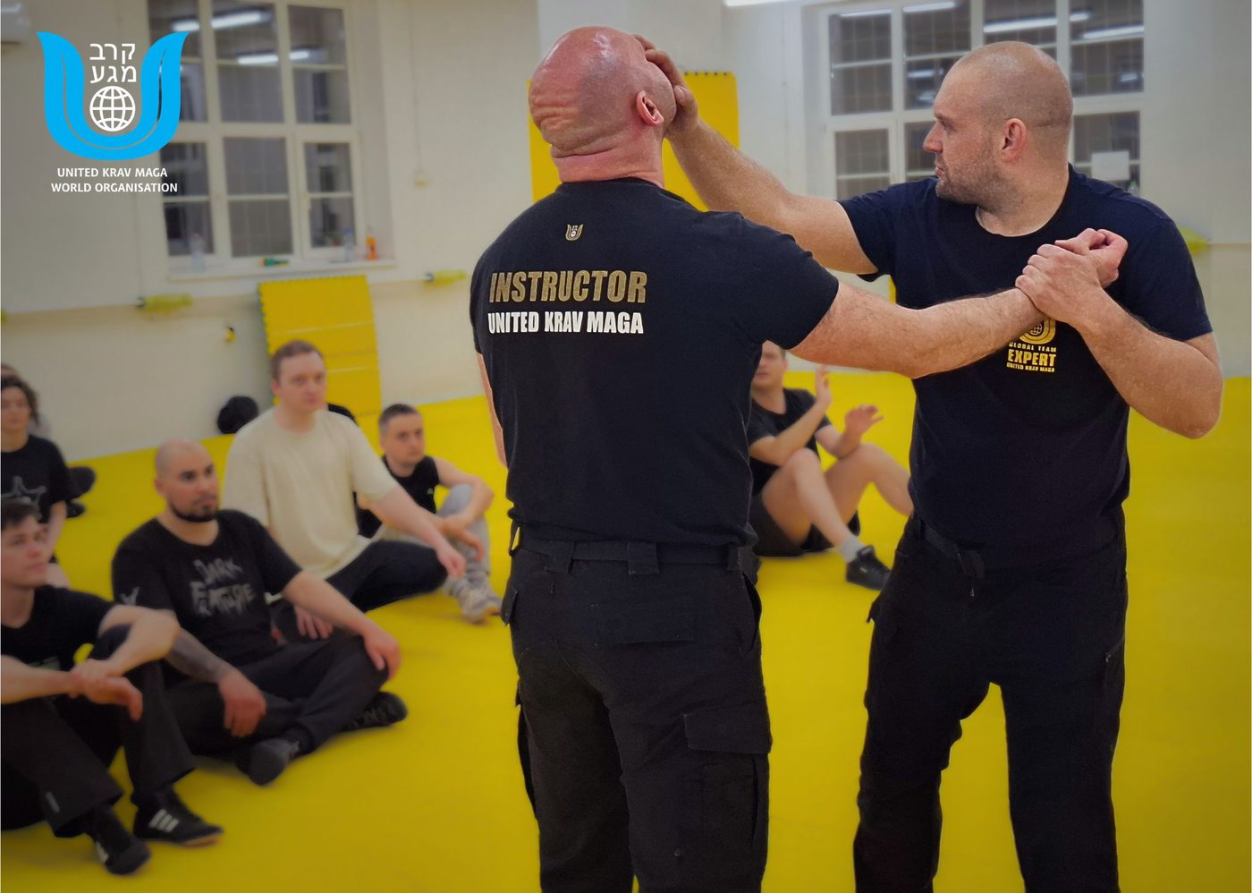 Instruktorzy United Krav Maga pokazują technikę grupie